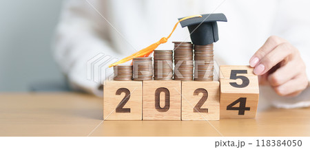 2024 end year to Happy New Year 2025 with Coins stack growing up and graduation hat. Money saving for Education, Scholarship, Student loan and debt and study future plan concept 118384050