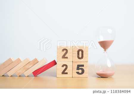 wood block falling to 2025 year with hour glass or sandglass. risk management, financial, deflation and Inflation, Insurance and economic recession concepts wood block falling to 2025 year with hour glass or sandglass. risk management, financial, deflation and Inflation, Insurance and economic recession concepts 118384094