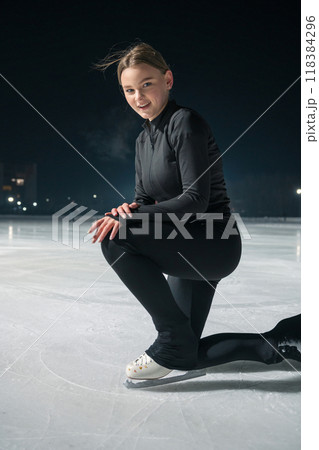 Beautiful young woman ice skating and performing short program 118384296
