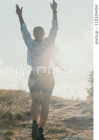 Woman Hiking Mountain Peak Celebrating Success Woman Hiking Mountain Peak Celebrating Success 118384404