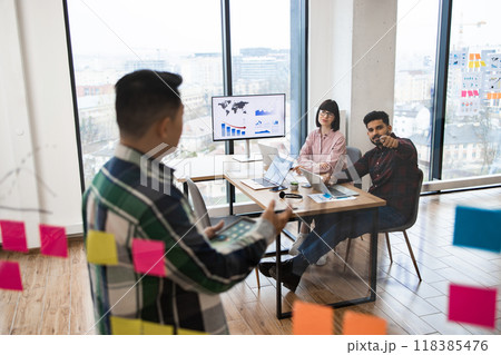 Team brainstorming session in modern office with sticky notes 118385476