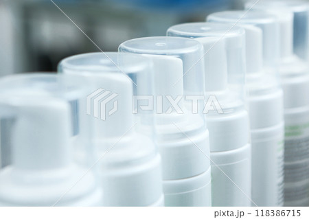 Bottles without labels at the cosmetics factory. Production of cosmetics and skin care products. A white plastic bottle. Bottles without labels at the cosmetics factory. Production of cosmetics and skin care products. A white plastic bottle. 118386715