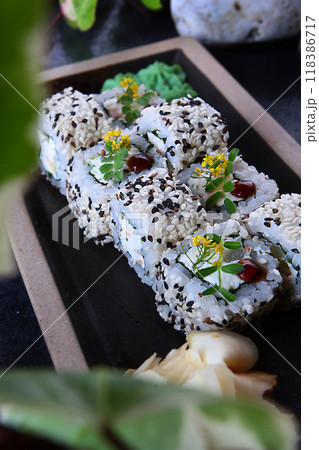 Sushi or rolls with smoked chicken, sesame and pineapple on a blackboard. Japanese cuisine. 118386717