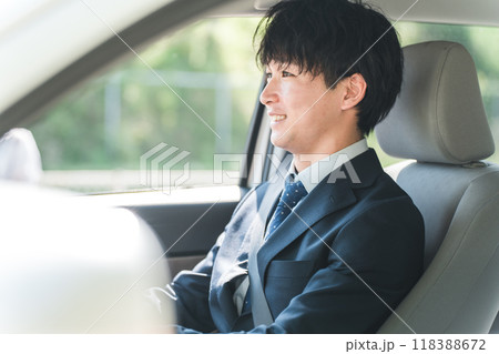 車を運転するスーツ姿の若い男性ビジネスマン 車を運転するスーツ姿の若い男性ビジネスマン 118388672