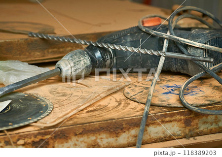 Electric hammer drill on metal surface with drills. Construction 118389203