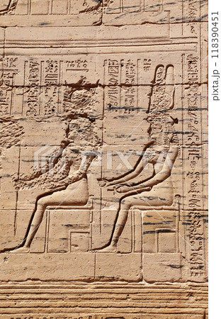 Ancient Egyptian bas-relief on stone wall. Figure of the goddess Isis. Temple of Isis on Agilkia Island (Philae), reservoir of Aswan Low Dam, Egypt 118390451