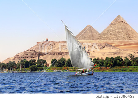 Famous Great Pyramids of Chephren and Cheops and traditional sailing boat felucca, Nile river, Egypt. A famous tourist attraction - sailing boat ride 118390458
