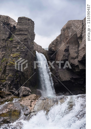 Icelandic natural waterfall surrounded by rocks Icelandic natural waterfall surrounded by rocks 118390487