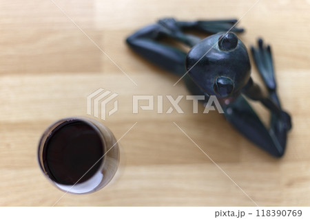Toy frog meditating with wine Toy frog meditating with wine 118390769