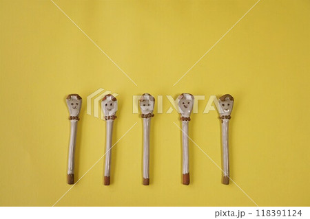 黄色の背景に置いた陶器製のスプーン 118391124