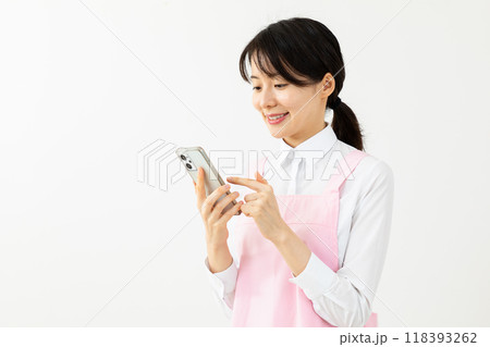 スマホを操作するエプロン姿の女性05 スマホを操作するエプロン姿の女性05 118393262