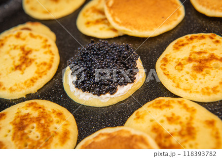 Blinis with black caviar and cream cheese, on a festive dish, mini pancakes, an elegant appetizer 118393782