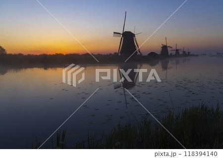 Traditional Dutch windmills with a colourful sky just before sunrise in Kinderdijk, The Netherlands Traditional Dutch windmills with a colourful sky just before sunrise in Kinderdijk, The Netherlands 118394140