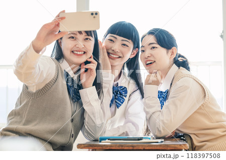 友達と一緒にスマホで写真を撮る女子高校生 友達と一緒にスマホで写真を撮る女子高校生 118397508