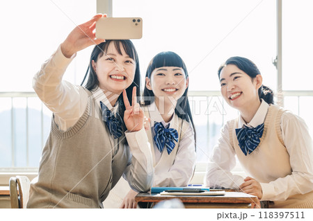 友達と一緒にスマホで写真を撮る女子高校生 118397511