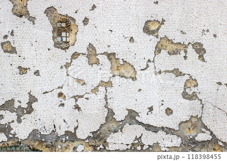 Closeup of a brick wall with white paint peeling off 118398455