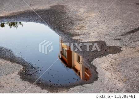 A beautiful house is vividly reflected in a puddle of water 118398461