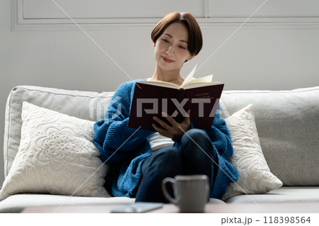 ソファで読書をするミドルの女性 ソファで読書をするミドルの女性 118398564