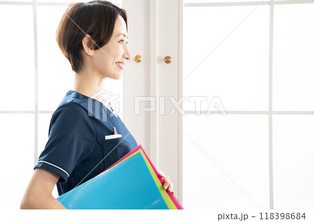 バインダーを持つミドルの女性スタッフ バインダーを持つミドルの女性スタッフ 118398684