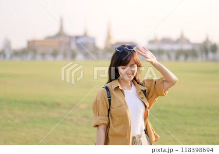 A Traveler Asian woman in her 30s exploring Wat Pra Kaew. From stunning architecture to friendly locals, she cherishes every moment, capturing it all in her heart and camera for years to come. A Traveler Asian woman in her 30s exploring Wat Pra Kaew. From stunning architecture to friendly locals, she cherishes every moment, capturing it all in her heart and camera for years to come. 118398694