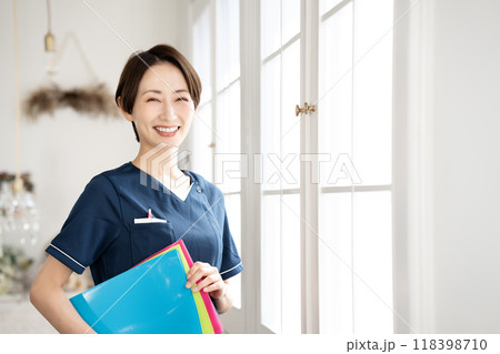 バインダーを持つミドルの女性スタッフ バインダーを持つミドルの女性スタッフ 118398710