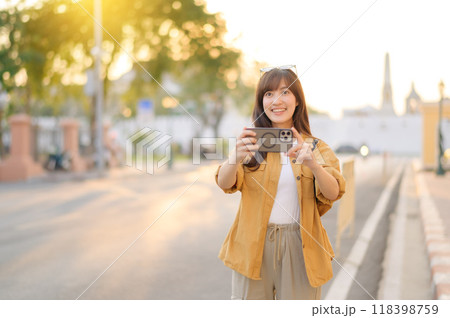 Traveler asian woman in her 30s using smartphone to take a photo while traveling urban street in Bangkok, Thailand 118398759