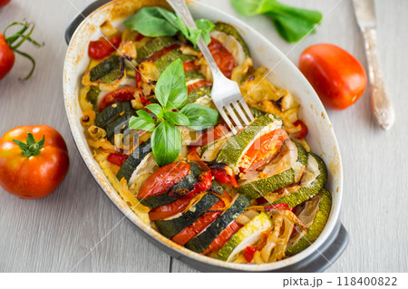 prepared baked zucchini and tomatoes in circles in a ceramic form, vegetable snack 118400822