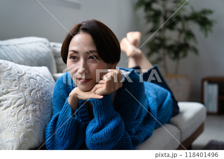 ソファーに寝転んでくつろぐミドル女性 118401496
