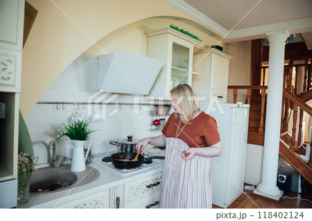 Woman Cook Housewife Cooking Delicious Food On Stove In Kitchen 118402124
