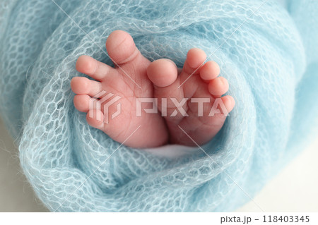 Close-up of tiny, cute, bare toes, heels and feet of a newborn girl, boy. Baby foot on blue soft coverlet, blanket. Detail of a newborn baby legs. Macro horizontal professional studio photo.  118403345