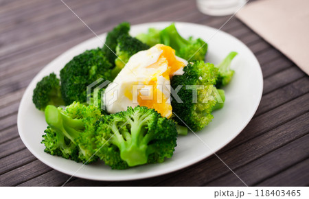 Boiled broccoli inflorescences with boiled egg in plate 118403465