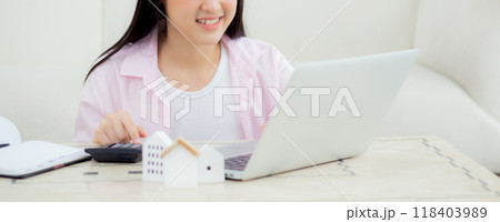 Young asian woman sitting and planning and calculate expense and mortgage with calculator and home. Young asian woman sitting and planning and calculate expense and mortgage with calculator and home. 118403989