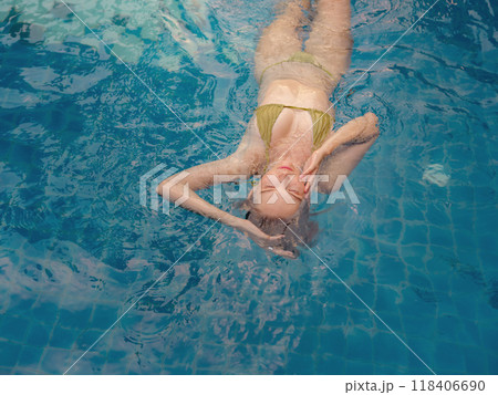 Vacation lifestyle scene of young woman sitting in swimming pool in morning time. Weekend and holiday lifestyle concept. 118406690