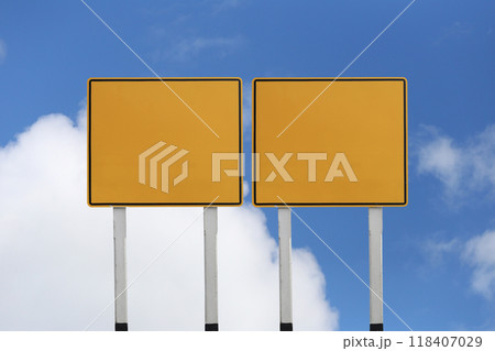 Empty yellow road sign with a background of blue sky and white clouds. 118407029