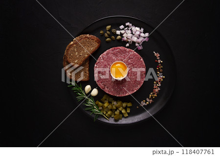 Beef tartare, with egg , capers, gherkins and bread,on a black background, top view, close up, horizontal, no people, Beef tartare, with egg , capers, gherkins and bread,on a black background, top view, close up, horizontal, no people, 118407761