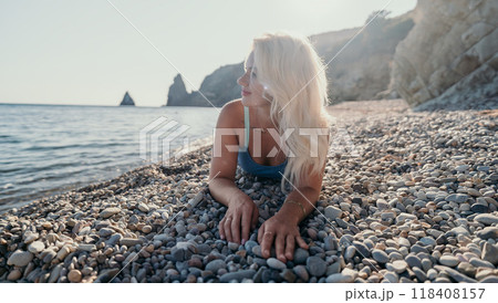 Woman Relaxing on a Pebble Beach Woman Relaxing on a Pebble Beach 118408157