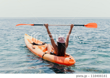 Kayaking Woman Ocean Paddle Happy - A woman paddles a kayak in the ocean with her arms raised in the air. 118408181