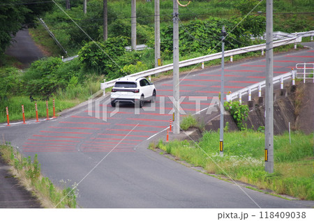 山の斜面をカーブしながら駆け上る急な勾配の舗装道路 118409038