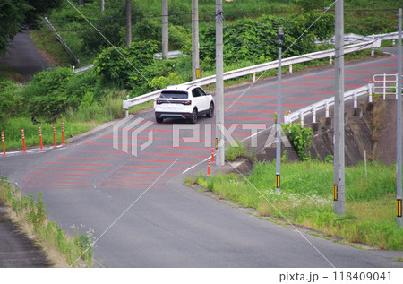 山の斜面をカーブしながら駆け上る急な勾配の舗装道路 118409041