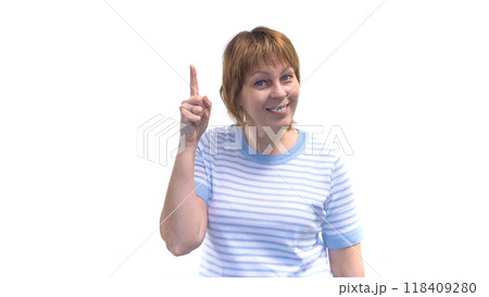 A beautiful woman smiles at the camera and raises her index finger A beautiful woman smiles at the camera and raises her index finger 118409280