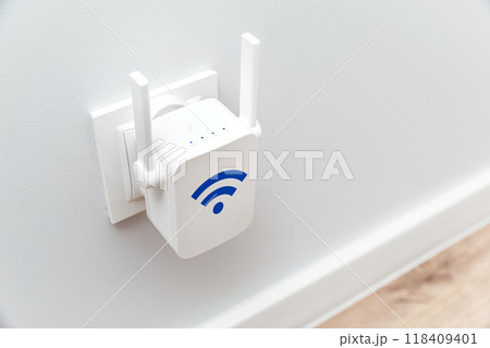 Wireless Wi-Fi repeater on white wall indoors 118409401