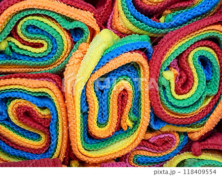 Many colorful folded microfiber cloths on a shelf in a supermarket. 118409554