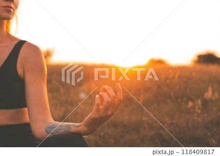 Yogi Woman in Lotus Pose Meditating at Sunset Yogi Woman in Lotus Pose Meditating at Sunset 118409817