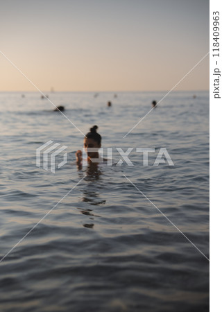 Experience the Serene Evening Swim in the Calm Waters of a Beautiful Tropical Ocean 118409963