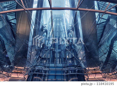 A modern tall building that features a significant amount of glass A modern tall building that features a significant amount of glass 118410195