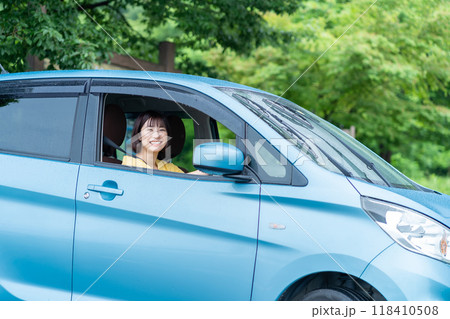 車を運転する女性　車の運転席に座る女性 118410508