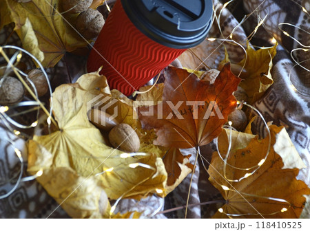 glass with a hot drink: coffee, cocoa or tea on yellow leaves glass with a hot drink: coffee, cocoa or tea on yellow leaves 118410525