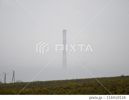 The power plant chimney is hidden by layers of morning fog The power plant chimney is hidden by layers of morning fog 118410526