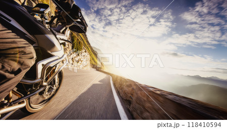 Motorbiker riding in Alps, dramatic sky. Travel and freedom, outdoor activities 118410594