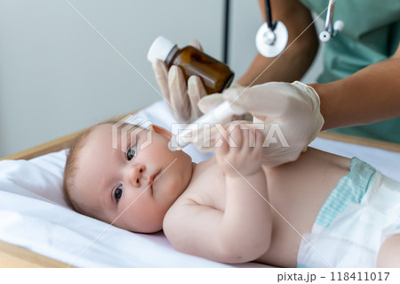 Nurse gives oral remedy to newborn in the hospital room Nurse gives oral remedy to newborn in the hospital room 118411017